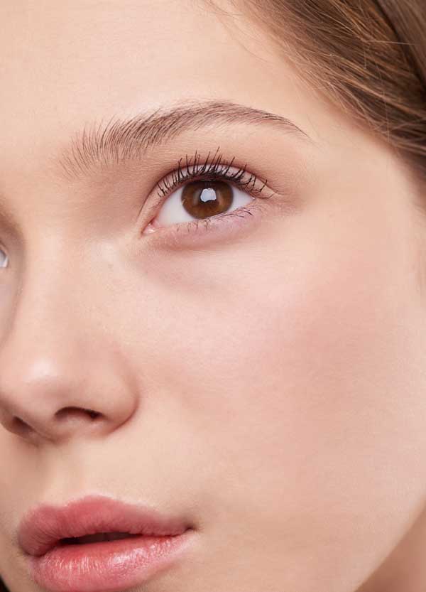 Close-up of a woman’s face showing natural skin and minimal makeup before any makeover.