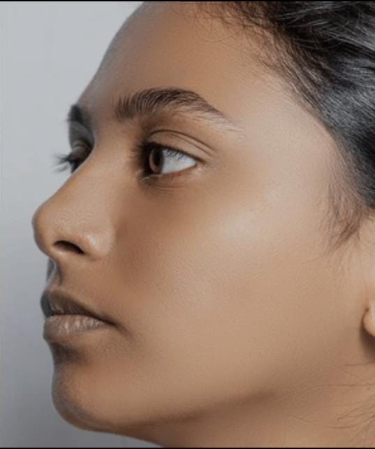 Close-up side view of a woman with a smooth, even-toned makeup base showing a natural matte finish.