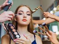 Makeup artist applying cosmetics using multiple beauty tools on a model